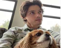 The actor is accompanied by a cute dog in his home.